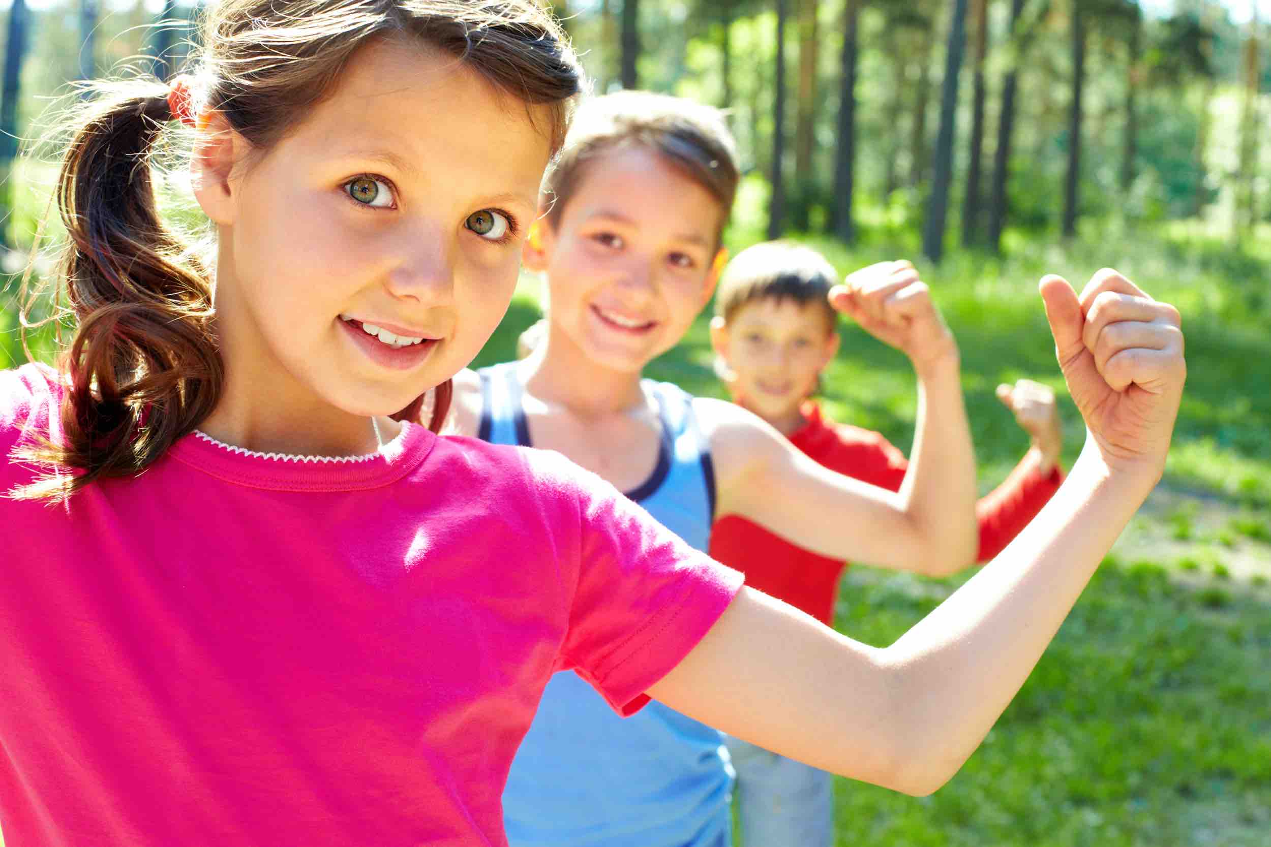 3 kids with left arm up showing off their bicep muscle
